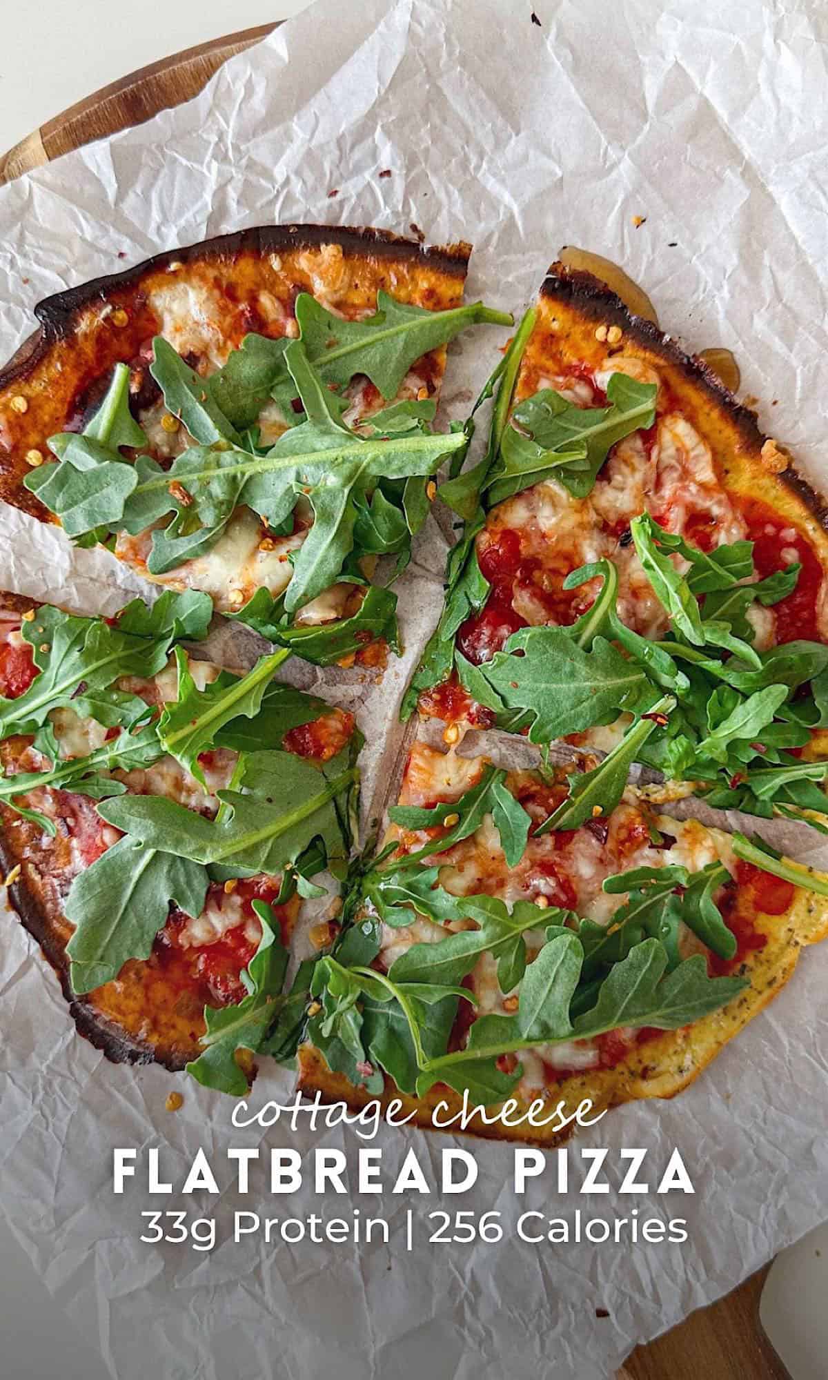 Cottage Cheese Flatbread Pizza 5 Cottage cheese flatbread pizza topped with tomato sauce, melted cheese, and fresh arugula, served on parchment paper over a wooden board.