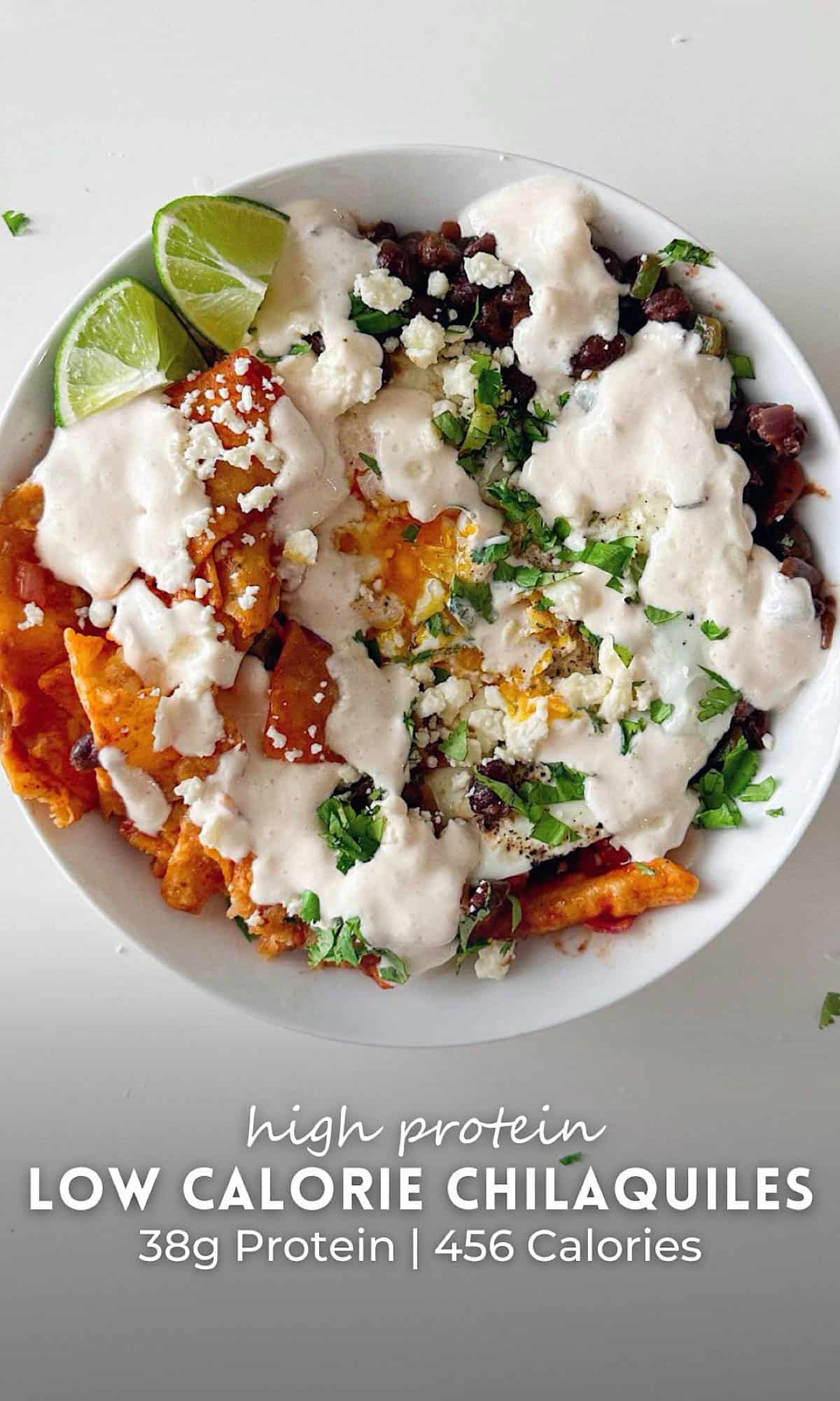 High protein low calorie chilaquiles made with tortilla chips, black beans, fried eggs, and a creamy cottage cheese lime sauce, topped with fresh cilantro and lime wedges.