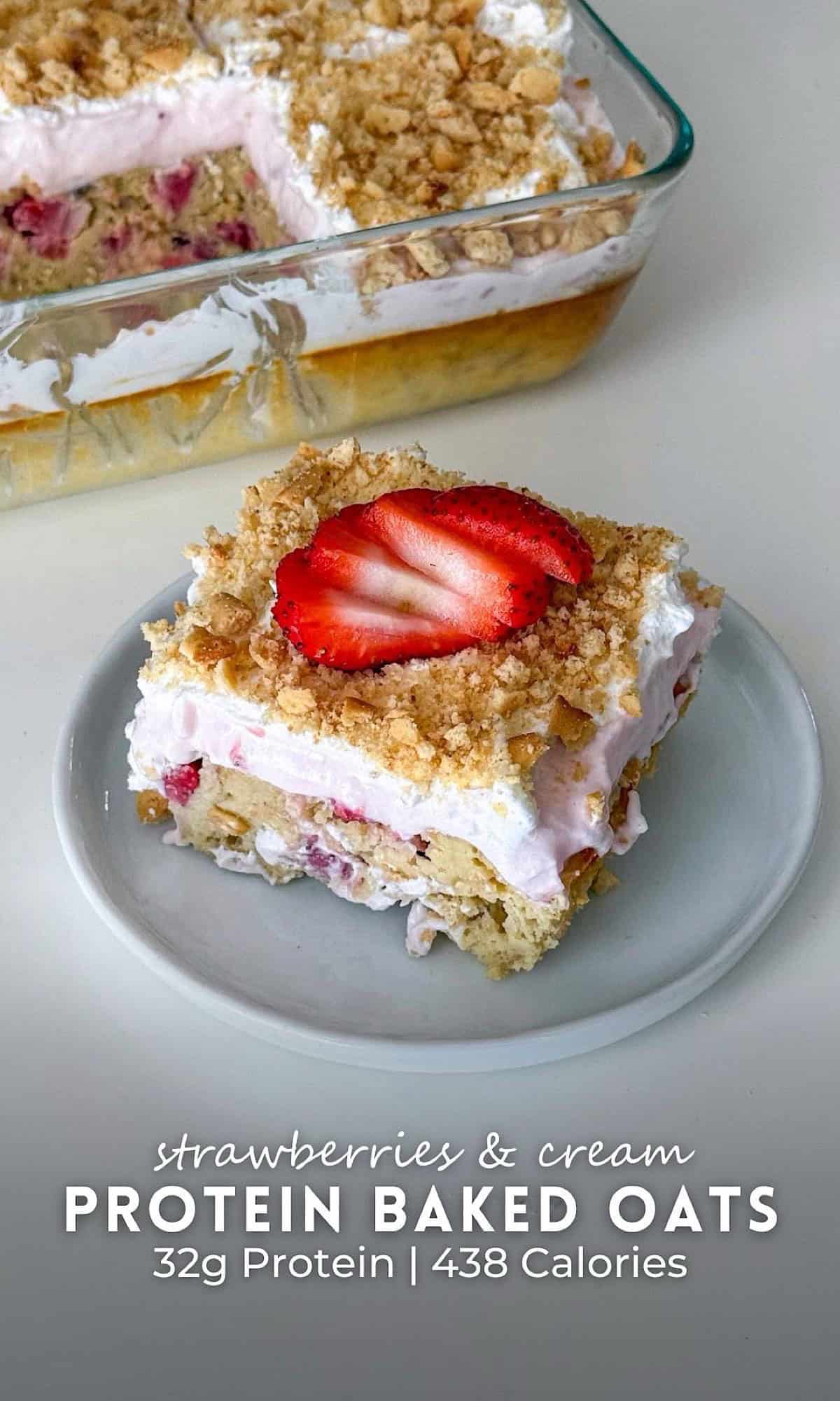 Strawberries and Cream Baked Oats 12 Slice of strawberries and cream baked oats topped with whipped cream and a fresh strawberry slice, served on a small plate with the rest of the baked oats in a glass dish behind it.