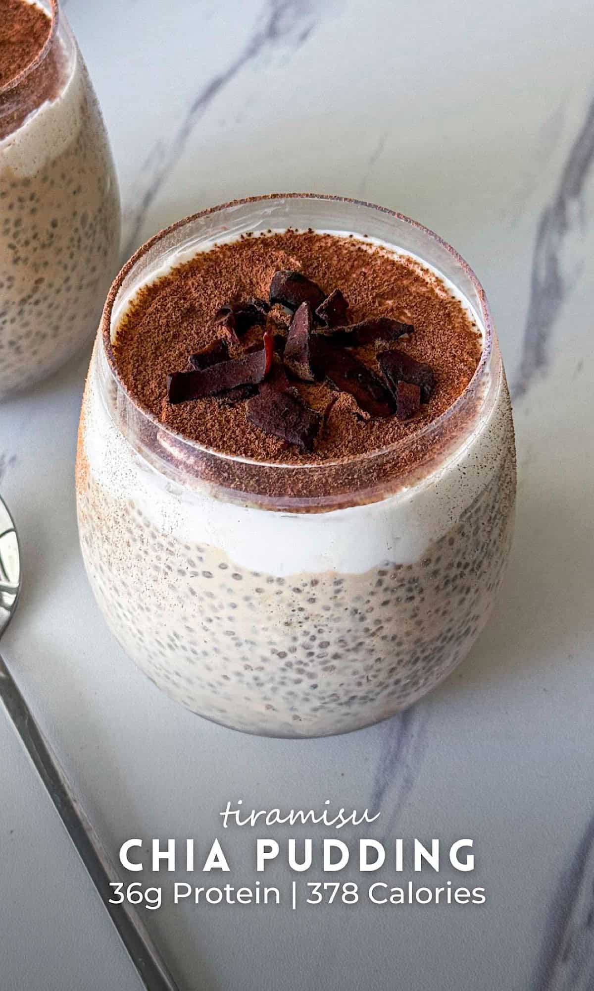 Two jars of tiramisu chia pudding layered with creamy chia mixture and yogurt, topped with cocoa powder and chocolate shavings, with a spoon on the side.