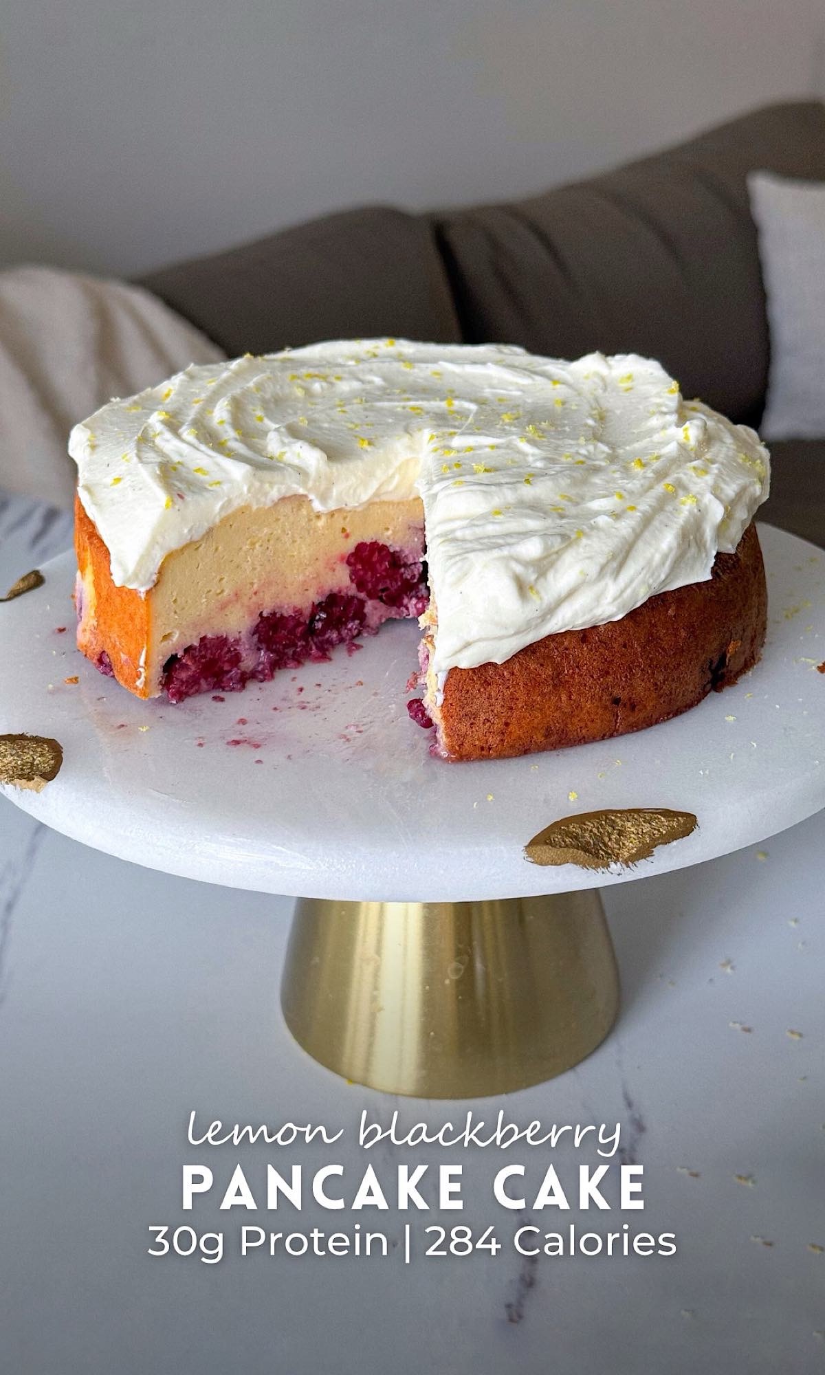 Lemon Blackberry Pancake Cake 10 Lemon blueberry pancake cake with a fluffy lemon cake layer baked over juicy blueberries, topped with a thick whipped lemon frosting and fresh lemon zest on a white cake stand.