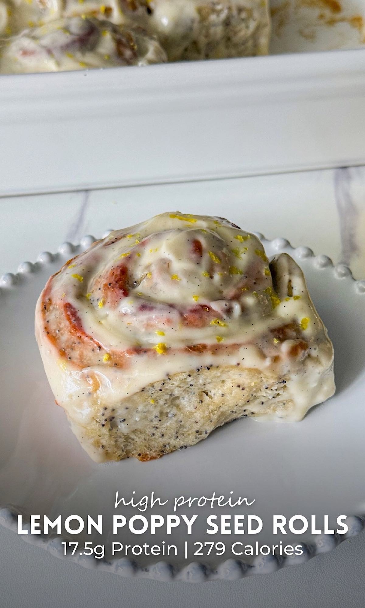 Lemon Poppy Seed Rolls 9 Soft and fluffy lemon poppy seed rolls covered in a thick lemon cream cheese glaze, with visible poppy seeds and fresh lemon zest on top, served on a white beaded plate.