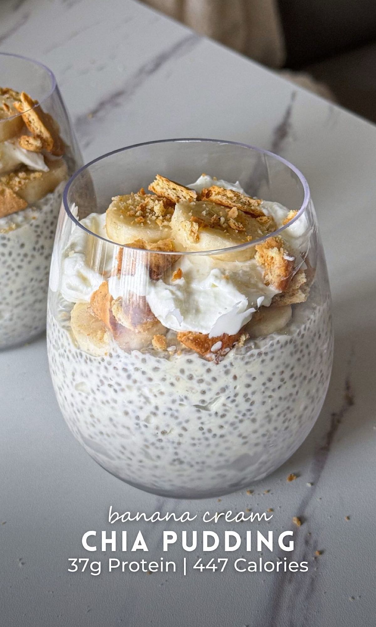 Banana cream chia pudding layered in clear glasses with a creamy vanilla chia pudding base, fluffy whipped topping, fresh banana slices, and crushed vanilla wafer cookies. This high protein banana cream chia pudding is served as a make-ahead breakfast or healthy dessert with a rich, creamy texture and classic banana cream pie flavor.
