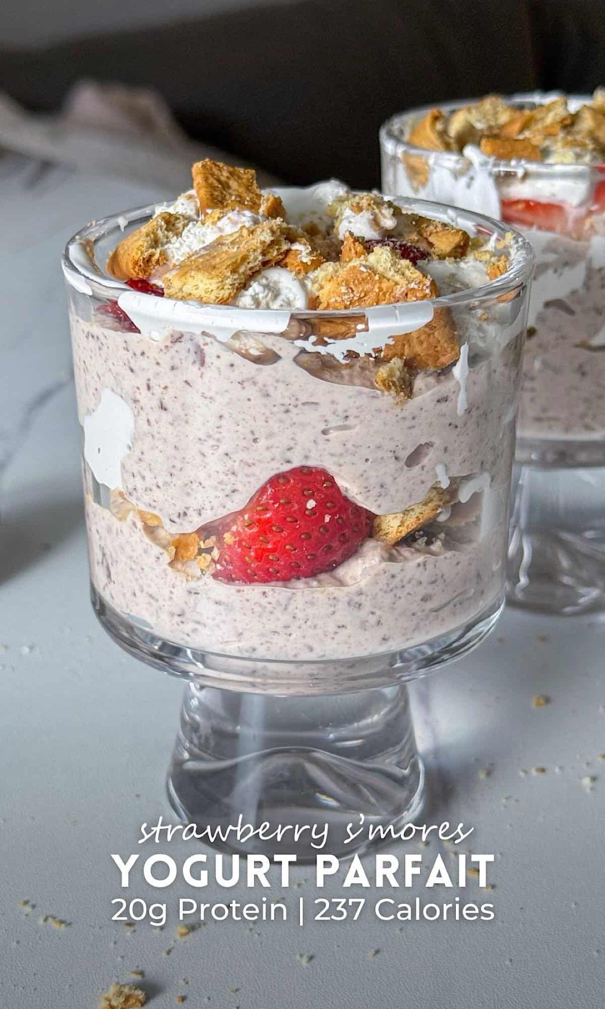 Strawberry S’mores Yogurt Parfait 9 Strawberry s’mores yogurt parfait layered with creamy chocolate yogurt, fresh strawberries, whipped topping, and crushed graham crackers in clear dessert glasses.