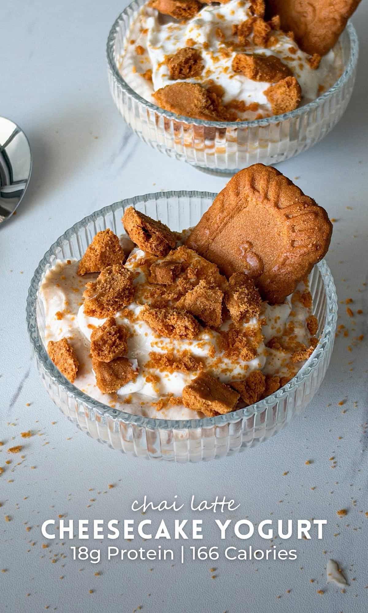 Chai Latte Cheesecake Yogurt 9 Chai latte cheesecake yogurt topped with creamy yogurt, crumbled Biscoff cookies, and a whole Biscoff cookie in a glass dessert bowl.
