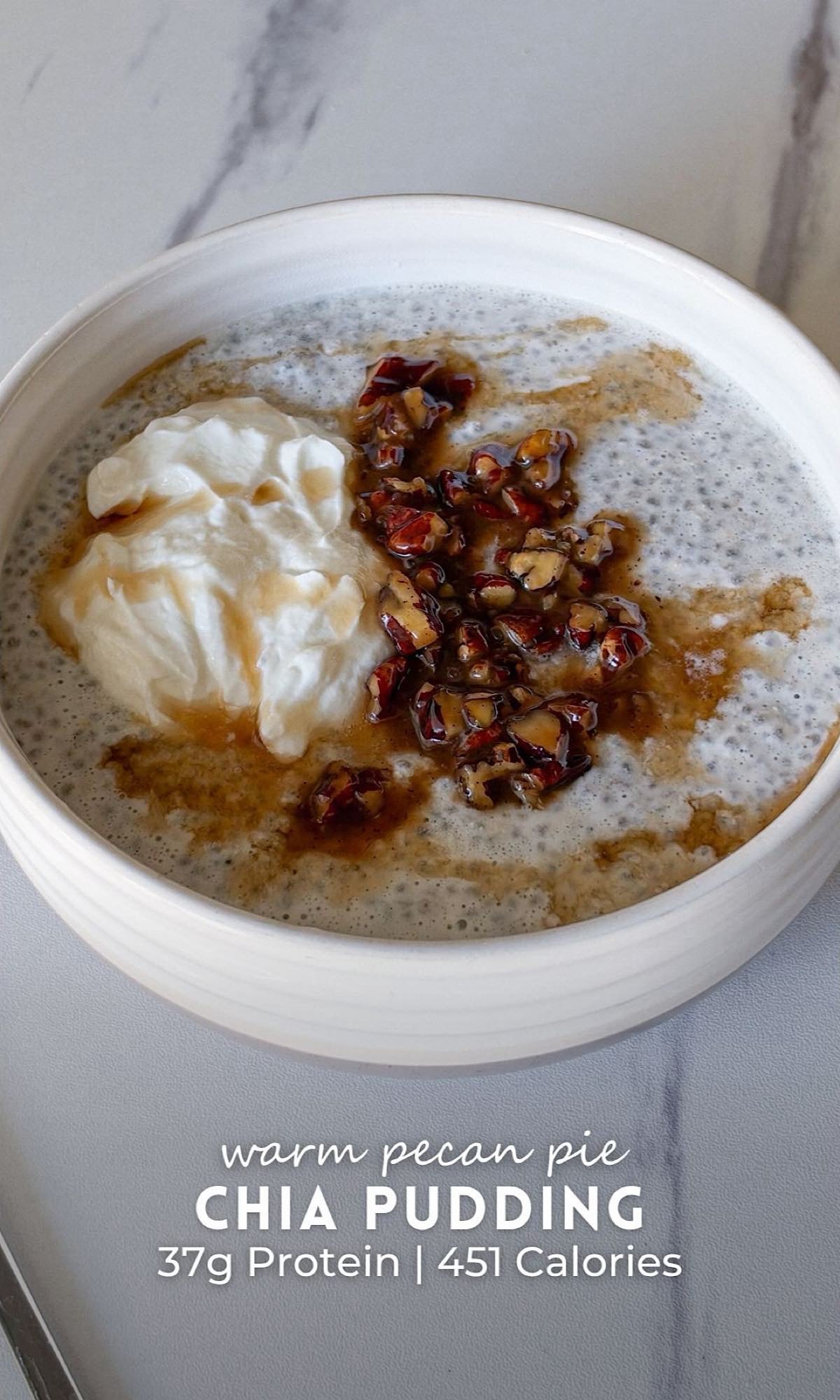 Warm Pecan Pie Chia Pudding 10 Pecan pie chia pudding in a white ceramic bowl, topped with a dollop of creamy Greek yogurt, caramelized pecans, and a drizzle of maple syrup on a marble countertop.