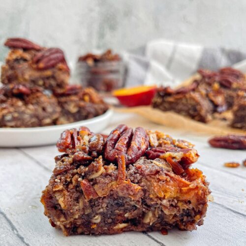 head on shot of one Vegan Peach Crumble Bar with Candied Pecans with other bars blurred in the background